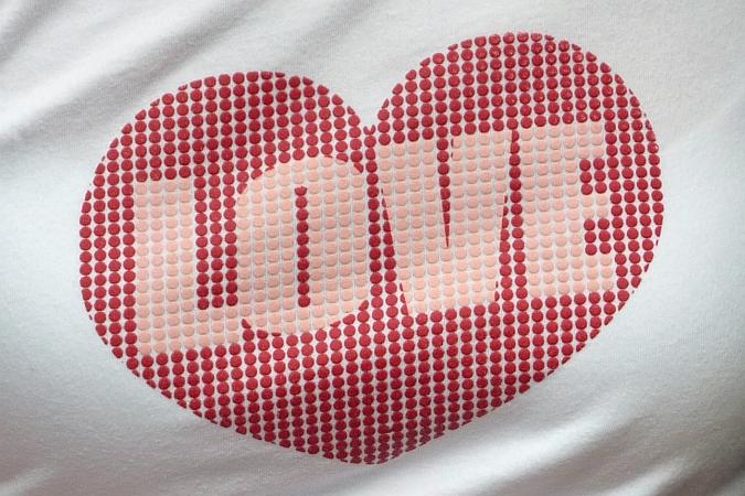 Brustbereich eines T-Shirt, auf dem ein rotes Herz mit der Inschrift "Love" ist